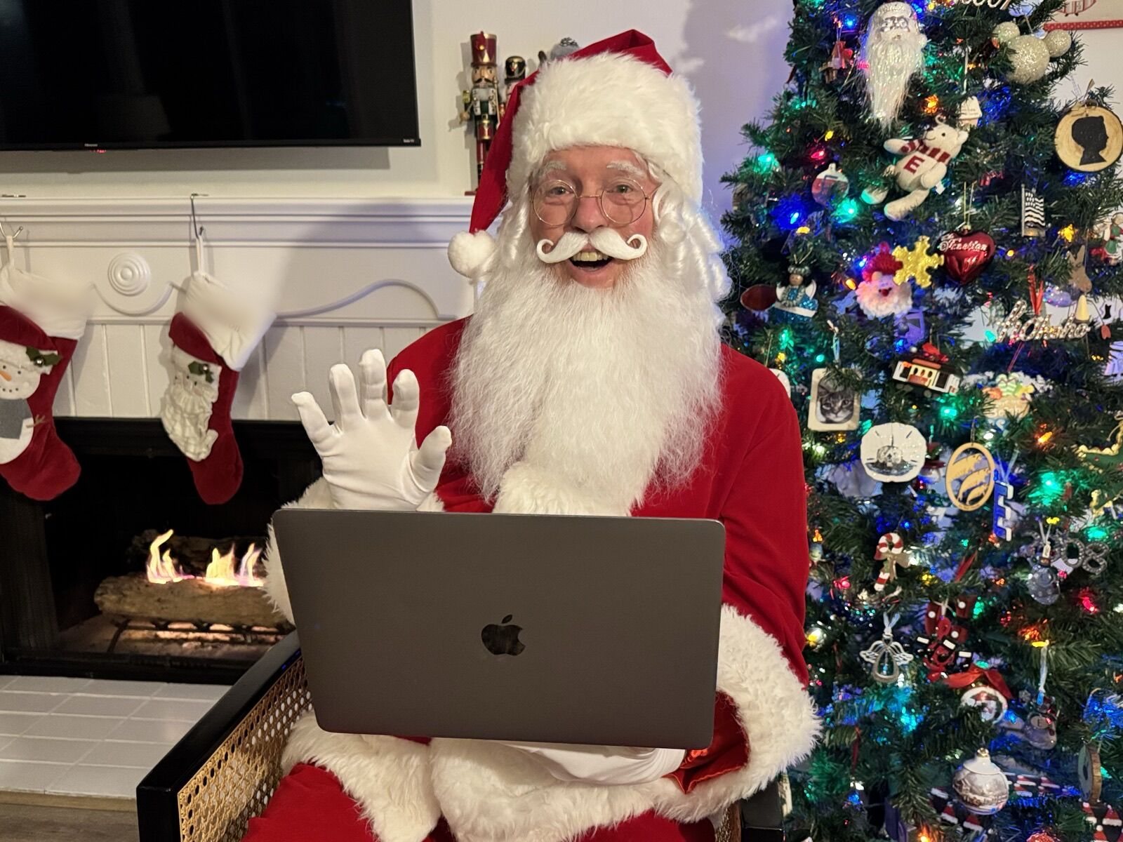 Santa on a laptop screen by the Christmas tree