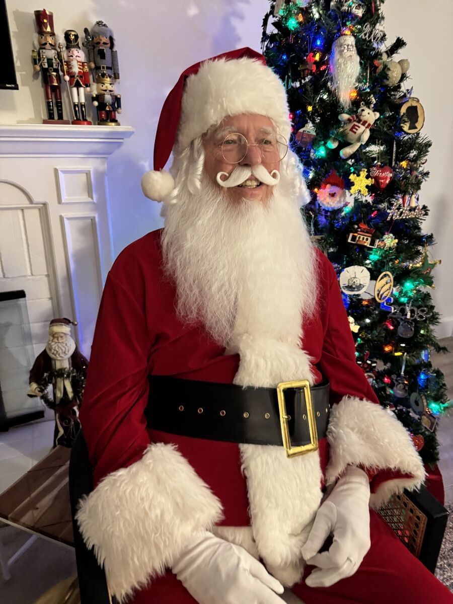 Santa Claus in a red velvet suit with white fur trim and a full white beard