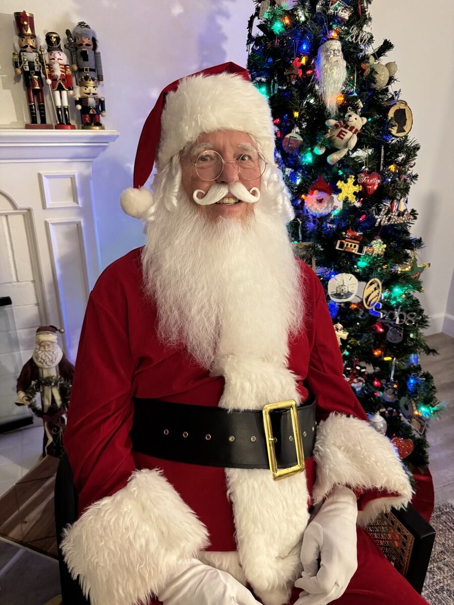 Close portrait of Santa Claus with his real white beard and velvet suit